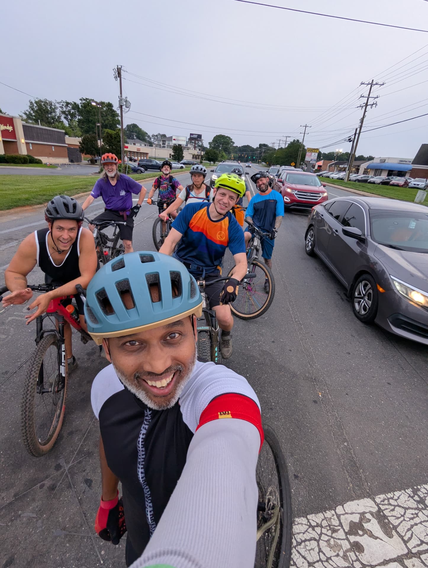 Sharif Rehman taking a selfie with a group ride of cyclists on a Gastonia road