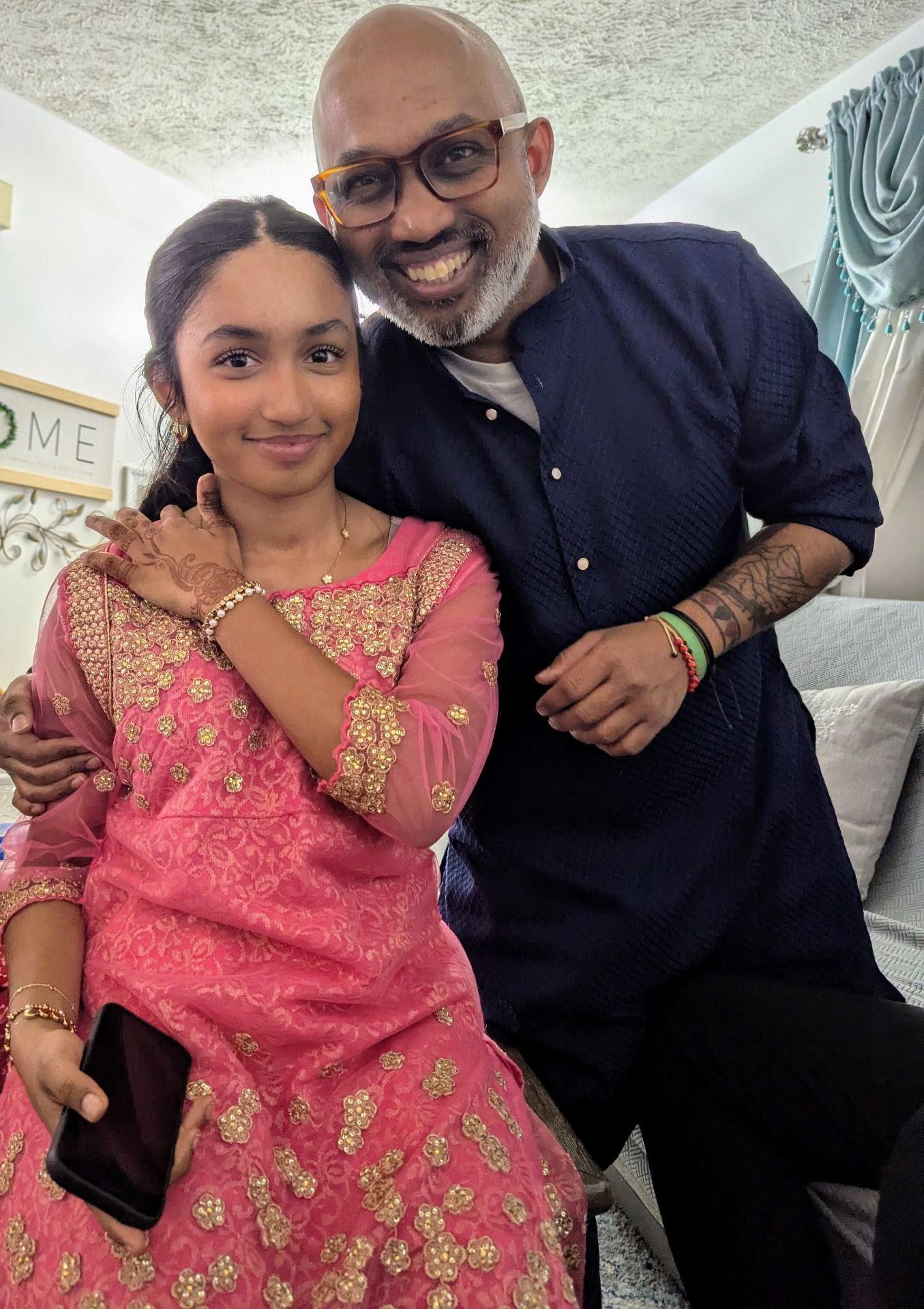 Sharif Rehman with his daughter wearing traditional cultural dress at a family celebration